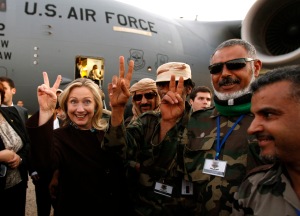 U.S. Secretary of State Hillary Clinton (C) gestures with Libyan soldiers upon her departure from Tripoli in Libya October 18, 2011. REUTERS/Kevin Lamarque (LIBYA - Tags: POLITICS TPX IMAGES OF THE DAY MILITARY) - RTR2ST1X